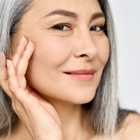 A portrait of an older woman admiring her aging skin and how to keep it looking wrinkle free and youthful