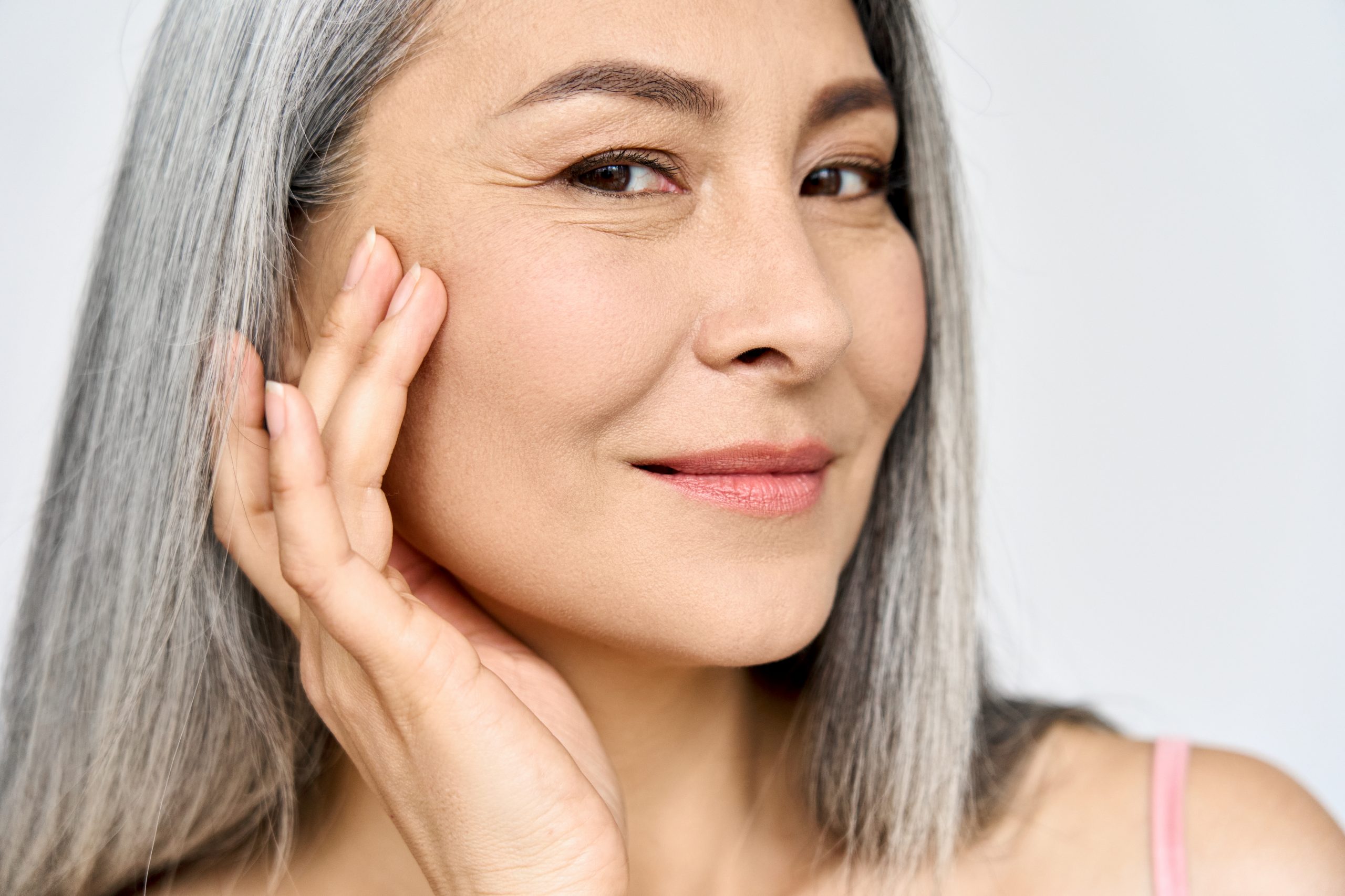 A portrait of an older woman admiring her aging skin and how to keep it looking wrinkle free and youthful